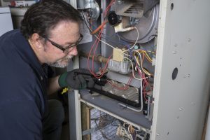 technician-looking-at-gas-furnace