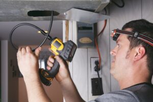 technician-using-tool-to-check-ductwork