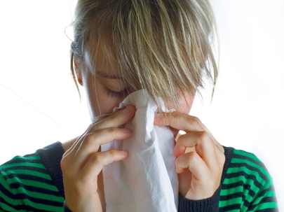 woman blowing her nose into a tissue